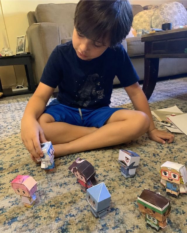 Niño jugando con personajes de papel 3D