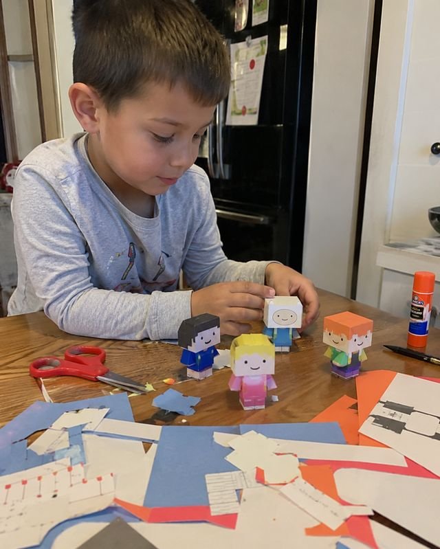 Niño recortando personajes de papel 3D